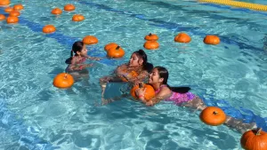 Kids collecting pumpkins in the Sierra Rec Center pool.