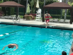 Lifeguard jumping into pool to rescue swimmer