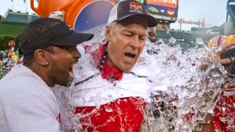 Coach Johnson being dumped with a bucket of water