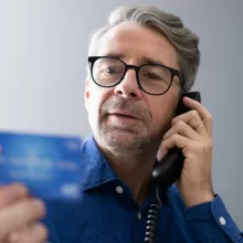 man on phone with credit card in hand