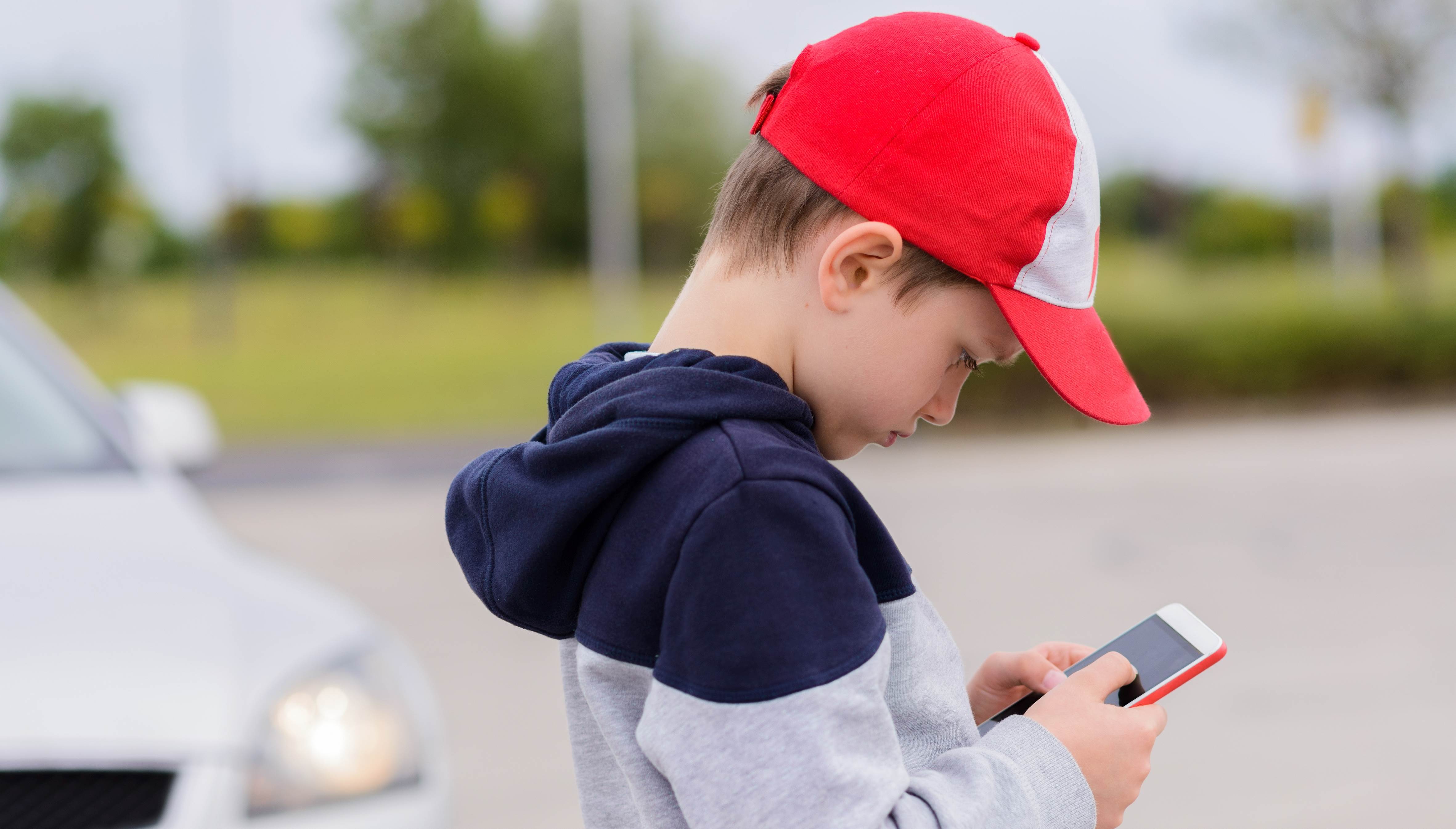 young boy looking at cell phone