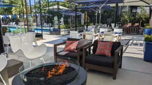 Montanoso Rec Center's outdoor deck space with lounge chairs, fire pits, TVs, and a pool.