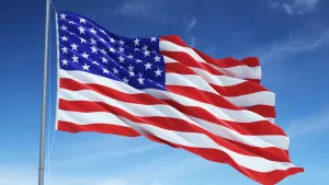 United States Flag on flag pole against blue sky
