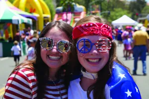 Two girls dressed in red, white & blue apparel.