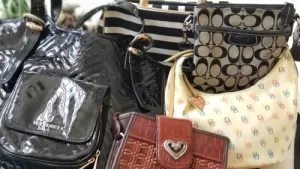 variety of purses in black, brown, beige and black and white stripes.