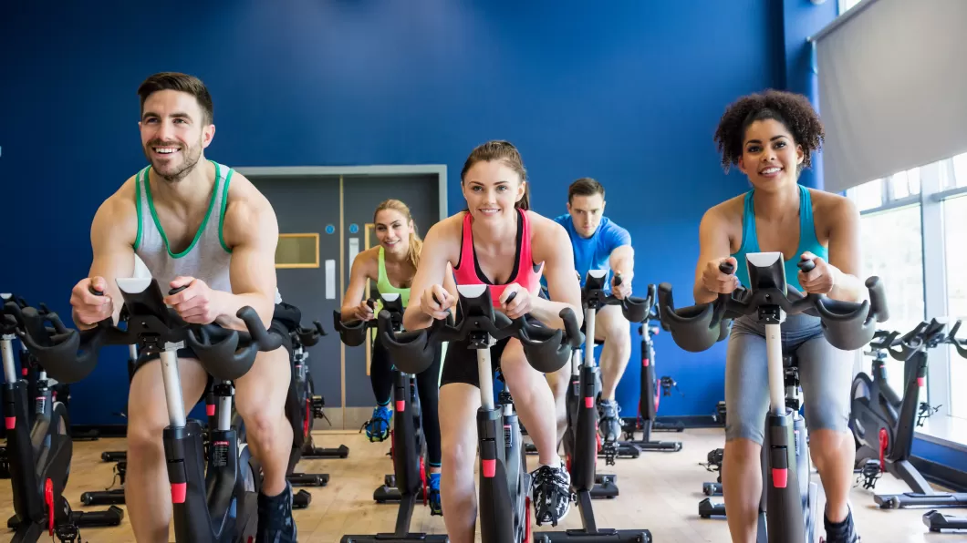 People taking an indoor cycling class