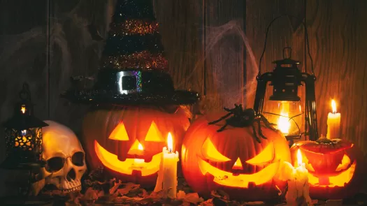 three jack-o-lanterns in a spooky setting