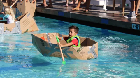 young boy in cardboard boat