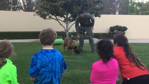 officer with training dog and young children