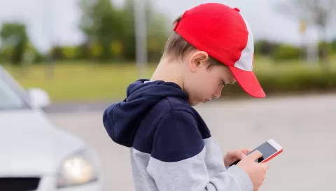 young boy looking at cell phone