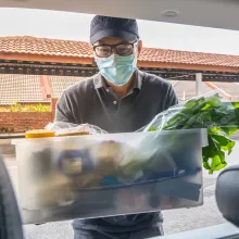 man putting food in car