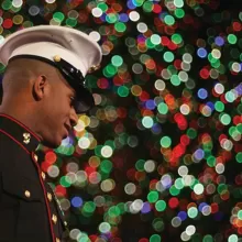 marine in front of holiday lights