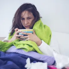 woman sick in bed with tea
