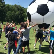group of kids with massive soccer ball
