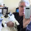 man holding cat taking a selfie