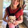 child holding dog in front carrier