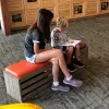 teen and girl sitting reading