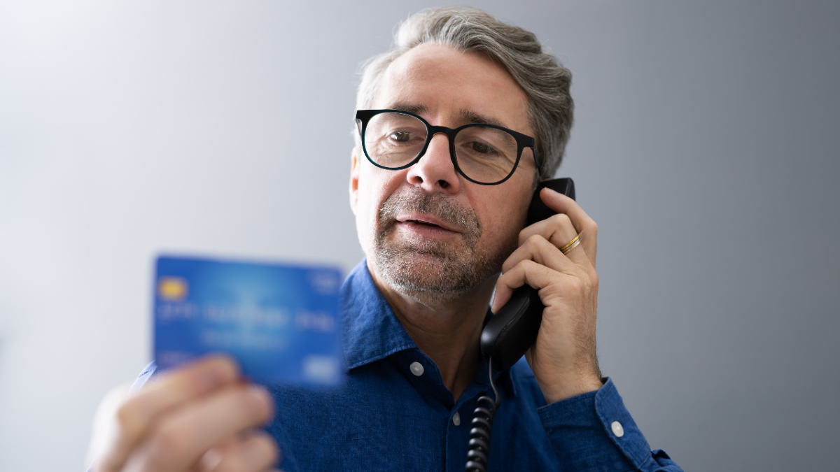 man on phone with credit card in hand