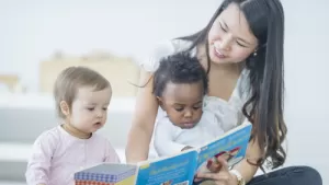Adult reading to two babies