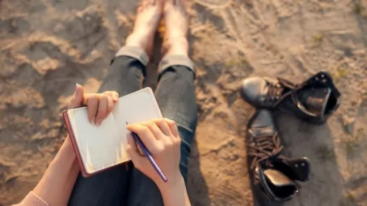 person writing poetry at the beach